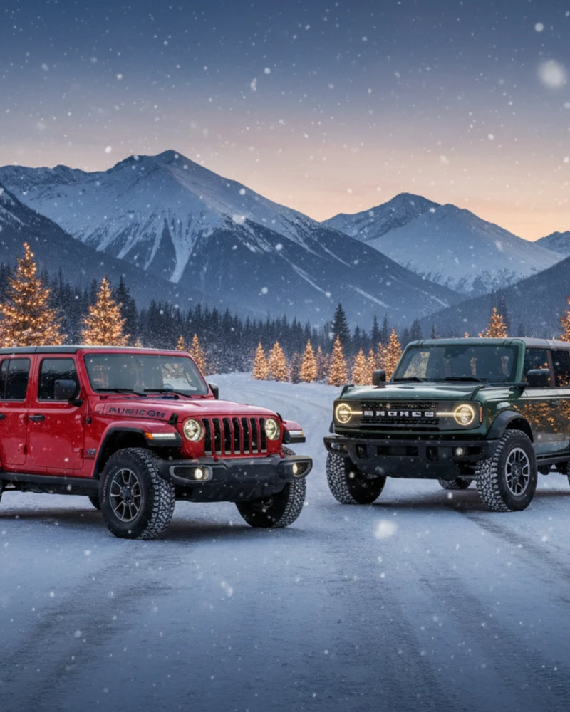 Jeep Wrangler and Ford Bronco parked in snowy mountains with Christmas lights — Hothead Headliners holiday sale hero image.