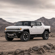 GMC HUMMER EV Pickup facing left in a rocky desert landscape