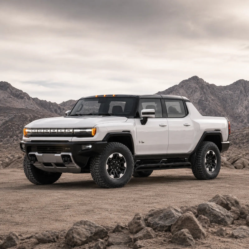 GMC HUMMER EV Pickup facing left in a rocky desert landscape