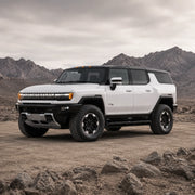 GMC HUMMER EV SUV facing left in a rocky desert landscape